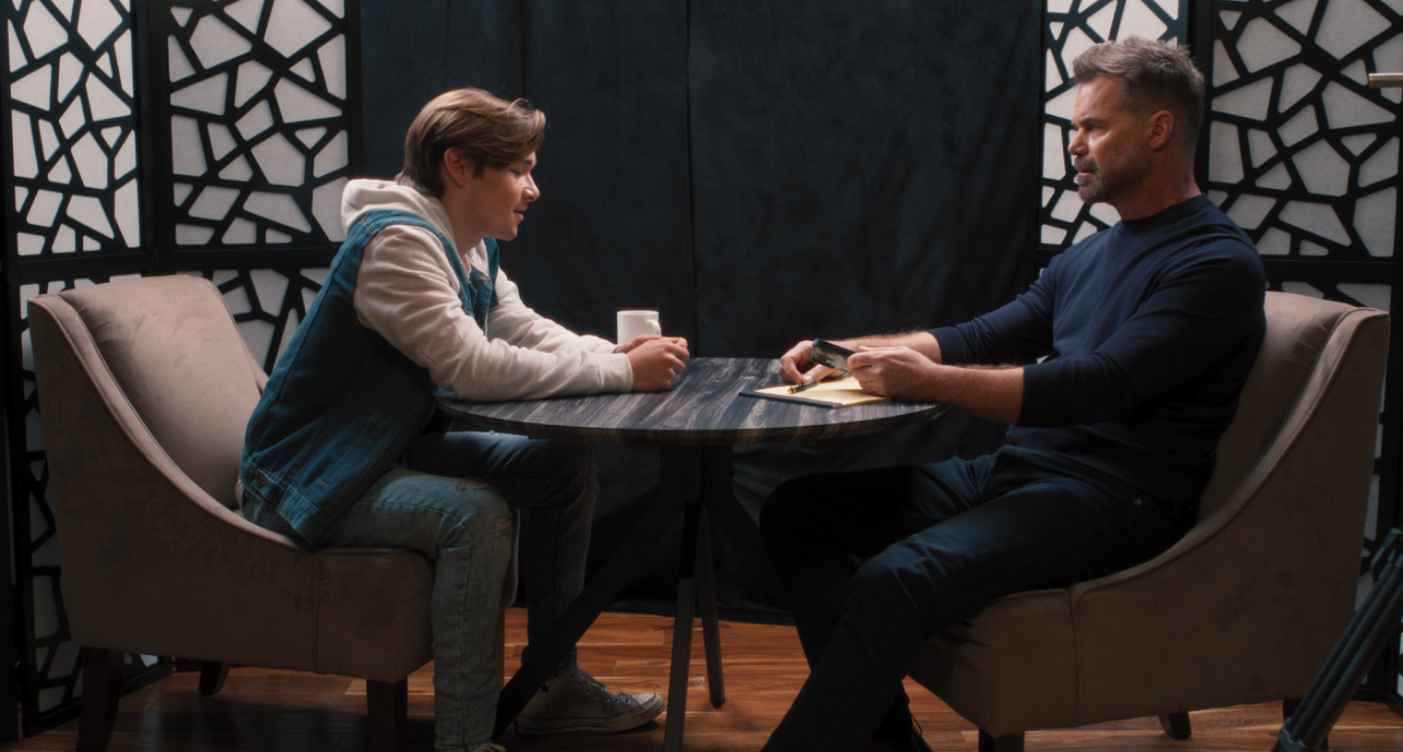 a yound man and an older man sitting at a table